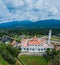 Aerial drone view of a white mosque known as Tun Khalil Mosque with Mount Ledang background at Asahan, Melaka, Malaysia.