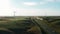 Aerial drone view windmills wind turbines producing clean ecological electricity by road in green agricultural fields on