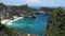 Aerial drone zooming view of tropical beach, sea rocks, turquoise ocean and palm trees. Atuh beach, Nusa Penida island