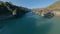 Aerial dynamic view sunny mountain landscape flying under bridge tourist people river water creek