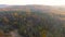 Aerial early cold sunny autumn morning view of trees and lake.