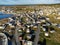 Aerial East Coast town with colourful beach homes on rocky shores and Canadian Tundra