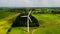 Aerial elevated partial orbit of rural wind turbines in the English countryside