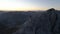 Aerial epic shot of a man standing on the edge of the mountain