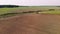 Aerial: farmer on a tractor plows the land before sowing with a modern revolving plow