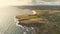 Aerial farmland at sun ocean bay. Nobody nature landscape. Farms and cottages at cereal fields