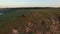 Aerial flight above couple in love walking on the river bank edge. Woman in amazing red dress. Man in black. Sunset.