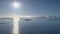 Aerial flight over Antarctica ocean. Bright sun.