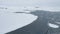 Aerial flight over Antarctica snow land and ocean.