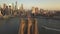 Aerial: flight over Brooklyn Bridge with American flag waving and East River view over Manhattan New York City Skyline