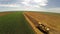 Aerial flight over combine harvesting the wheat rows