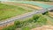 Aerial flight over the fields and the bridge river side. Vehicle going by the highway between cityes in Italy, Tuscany.