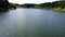 Aerial fly at high speed over water surface of a calm lake in summer Sunny day