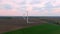 Aerial fly near wind turbine generator. Wind power plant placed on agriculture field. Concept of green and ecological energy. Summ