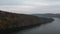 Aerial fly over river in canyon. Boat sailing on a wide river, rear view from above.