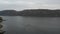 Aerial fly over river in canyon. Boat sailing on a wide river, rear view from above.