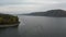 Aerial fly over river in canyon. Boat sailing on a wide river, rear view from above.