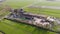 Aerial flyby shot of a beautiful farm in The Netherlands surrounded with Bright green Fields in an evening hour