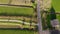 Aerial flyby shot of a beautiful farm in the Netherlands surrounded with Bright green Fields in an evening hour