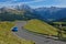 AERIAL: Flying above a cool blue sports car speeding up a scenic mountain road.