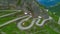 AERIAL: Flying above a hairpin road meandering up the beautiful Swiss mountains