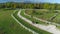 AERIAL: Flying above unrecognizable woman riding her mare down a gravel road.