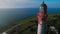 Aerial flying around an old working lighthouse with a beautiful ocean view.