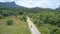 AERIAL: Flying behind female explorer riding her motorcycle into tropical jungle