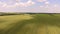 Aerial flying high above vast wheat field.