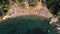 Aerial flying over beach umbrellas and sunbeds on the coast in Thassos island, Greece