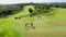 AERIAL: Flying over beautiful golf course on overgrown rocky cliff top in sunny luxury tourist resort on paradise island Bali, Ind