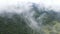 Aerial flying over the cloud, with mountain and road on the pass