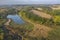 Aerial Flying over countryside with village, forest, ponds, and fields at autumn sunset time. Wonderful drone photo for ecological