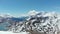 Aerial: flying over hikers on snowy mountain top, ski touring mountaineering snow mountain, panoramic view on the alps, conquering