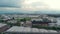 Aerial: flying over industrial district and farmland with mountain view and clouscape in the background, Turin, Italy