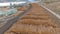 AERIAL: Flying over logs stacked into piles next to sawmill near country highway