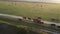 AERIAL: Flying over a small herd of cattle cows walking uniformly down farm road on the hill. Black, brown and spotted