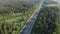 AERIAL: Flying view of a busy highway in picturesque nature during rush hour.