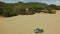 Aerial flyover of a man walking on a dry African river bed, dry season