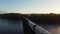 Aerial follow footage of freight train traversing elevated bridge over Catawba River in South Carolina. Rising shot.