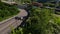 Aerial follow view summer alpine resort infrastructure white sport car riding serpentine road