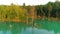 Aerial footage of azure waterscape inside artificial pit. Cherepashyntsi quarry with sandy banks and dense forest on the