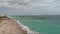 aerial footage of the blue ocean water along the coastline at Johnnie Mercer\\\'s Fishing Pier with homes, people on the sand