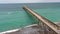 aerial footage of the blue ocean water along the coastline at Johnnie Mercer\\\'s Fishing Pier with people on the sand