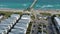 aerial footage of the blue ocean water along the coastline at Johnnie Mercer\\\'s Fishing Pier with people on the sand