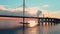 Aerial footage of cable-stayed bridge at sunset, car traffic on the highway over water, magic reflection on water, water