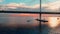 Aerial footage of cable-stayed bridge at sunset, car traffic on the highway over water, magic reflection on water, water