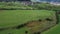 Aerial footage of cows. Dairy farm of a green field close to a small village