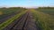 Aerial footage from a drone flying along a train track in a rural