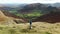 Aerial footage of female tourist enjoying the view of Great Langdale valley, UK